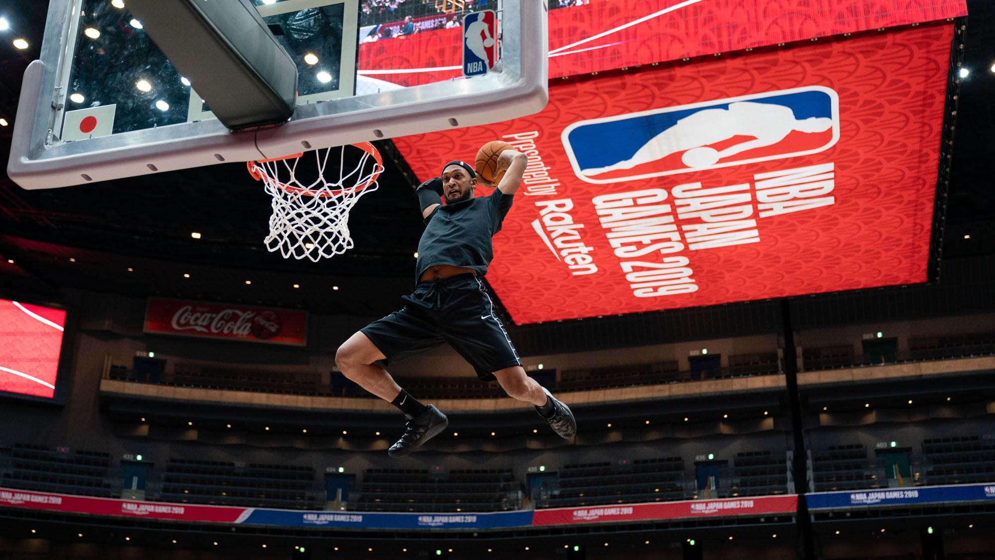 basketball player dunking with the NBA japan rakuten flyer in the background